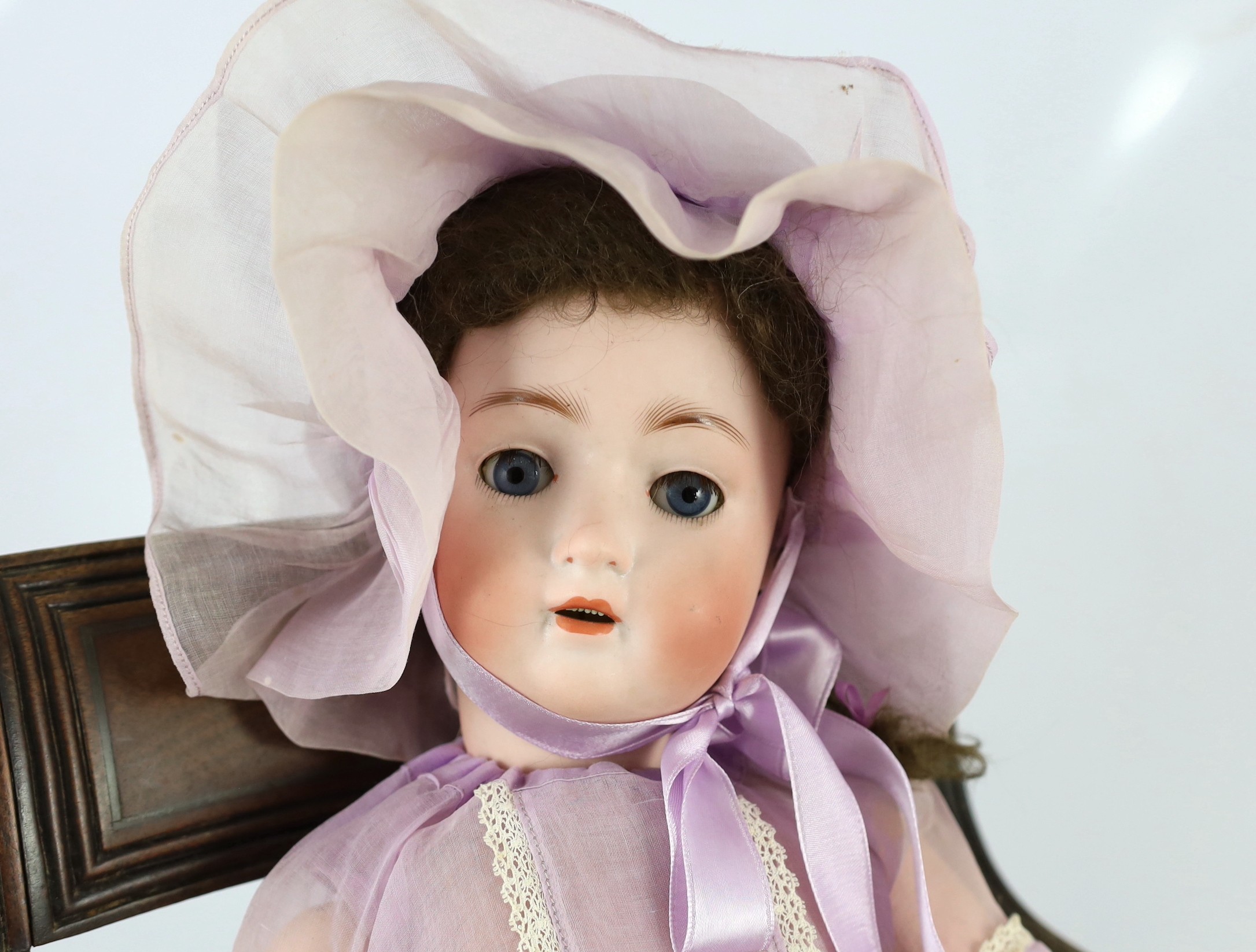 An Alt, Beck & Gottschalck bisque doll, German, circa 1912, 23in. Please note the chair is for display purposes only.
